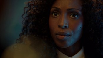 Movie still from “Slasher” (2016), created by Aaron Martin – A person with curly black hair; Close Up shot, Over the shoulder angle