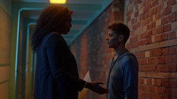 Movie still from “Slasher” (2016), created by Aaron Martin – A man and a woman are talking in a hallway; Medium shot, Over the shoulder angle