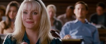 Movie still from “Spider-Man 3” (2007), directed by Sam Raimi – A woman sitting in front of a group of other people; Close Up shot, Over the shoulder angle