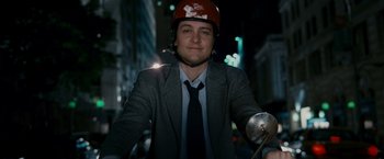 Movie still from “Spider-Man 3” (2007), directed by Sam Raimi – A man in a suit and helmet riding a bike; Medium shot, Overhead angle