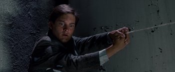Movie still from “Spider-Man 3” (2007), directed by Sam Raimi – A young man holding a gun in a dark room; Close Up shot, Overhead angle