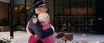 Movie still from “Spider-Man 3” (2007), directed by Sam Raimi – A police officer hugging a woman in front of a building; Medium shot, Over the shoulder angle