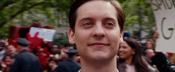 Movie still from “Spider-Man 3” (2007), directed by Sam Raimi – A man's face in front of a group of onlookers; Close Up shot, Over the shoulder angle