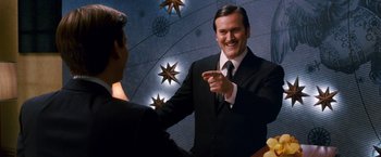 Movie still from “Spider-Man 3” (2007), directed by Sam Raimi – A man wearing a suit and tie is pointing at himself in the mirror; Medium shot, Low angle