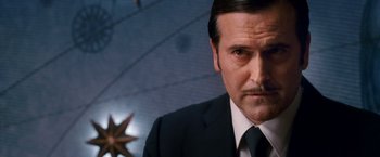 Movie still from “Spider-Man 3” (2007), directed by Sam Raimi – A man in a black suit and a black and white striped tie; Close Up shot, Low angle