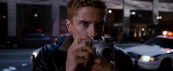 Movie still from “Spider-Man 3” (2007), directed by Sam Raimi – A man holding a camera up to his face; Close Up shot, Over the shoulder angle