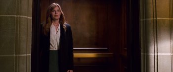 Movie still from “Spider-Man 3” (2007), directed by Sam Raimi – A woman standing in front of an elevator in a dark room; Medium shot, Low angle