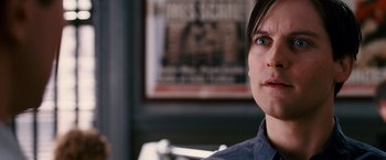 Movie still from “Spider-Man 3” (2007), directed by Sam Raimi – A man with a blue shirt is looking into the distance; Close Up shot, Over the shoulder angle