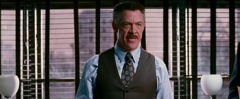 Movie still from “Spider-Man 3” (2007), directed by Sam Raimi – A man with a mustache wearing a suit and tie; Close Up shot, Over the shoulder angle
