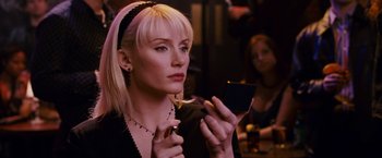 Movie still from “Spider-Man 3” (2007), directed by Sam Raimi – A woman looking at her cell phone while sitting at a table; Close Up shot, Over the shoulder angle