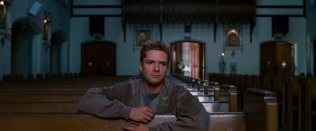 Movie still from “Spider-Man 3” (2007), directed by Sam Raimi – A man sitting on a bench in front of a church; Medium shot, Low angle