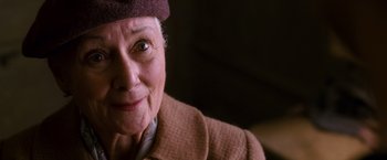 Movie still from “Spider-Man 3” (2007), directed by Sam Raimi – An older woman wearing a hat and a jacket; Close Up shot, Over the shoulder angle