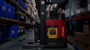 Movie still from “Breaking Bad” (2008), created by Vince Gilligan – A man is standing in a forklift in a warehouse; Wide shot, Low angle