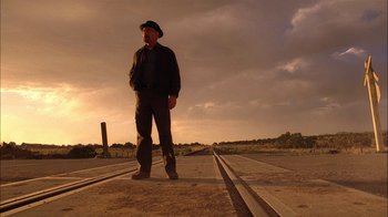 Movie still from “Breaking Bad” (2008), created by Vince Gilligan – A man standing on a train track in the middle of the day; Wide shot, Low angle