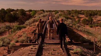 Movie still from “Breaking Bad” (2008), created by Vince Gilligan – Three men are walking along the railroad tracks; Wide shot, Low angle