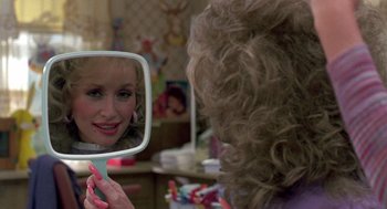 Movie still from “Steel Magnolias” (1989), directed by Herbert Ross – A woman looking into a mirror while holding a mirror; Close Up shot, Over the shoulder angle