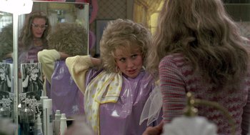 Movie still from “Steel Magnolias” (1989), directed by Herbert Ross – A young girl is looking in the mirror in a dressing room; Medium shot, Over the shoulder angle