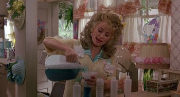 Movie still from “Steel Magnolias” (1989), directed by Herbert Ross – A woman in a yellow shirt is making candles; Medium shot, Over the shoulder angle