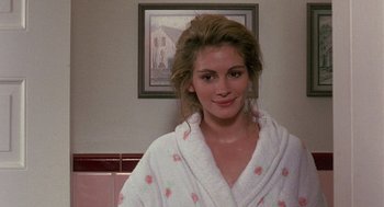 Movie still from “Steel Magnolias” (1989), directed by Herbert Ross – A woman wearing a robe in front of a picture; Close Up shot, Over the shoulder angle