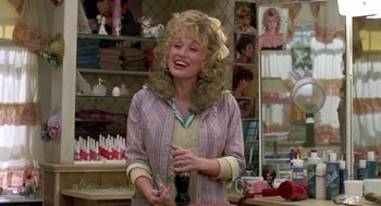 Movie still from “Steel Magnolias” (1989), directed by Herbert Ross – A woman with blonde curly hair is standing in a store; Medium shot, Over the shoulder angle