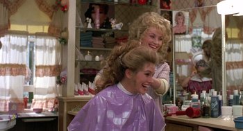 Movie still from “Steel Magnolias” (1989), directed by Herbert Ross – A woman getting her hair cut by a woman in a purple cape; Medium shot, Over the shoulder angle