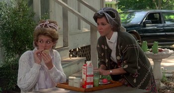 Movie still from “Steel Magnolias” (1989), directed by Herbert Ross – Two women sitting at a table with a tray of food on it; Medium shot, Over the shoulder angle