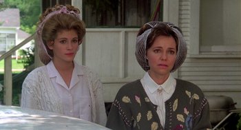 Movie still from “Steel Magnolias” (1989), directed by Herbert Ross – Two women standing next to each other in front of a house; Close Up shot, Over the shoulder angle