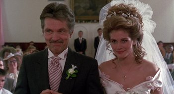 Movie still from “Steel Magnolias” (1989), directed by Herbert Ross – A man and a woman standing next to each other; Close Up shot, Low angle