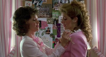 Movie still from “Steel Magnolias” (1989), directed by Herbert Ross – Two women in a room with a bunch of pictures on the wall behind them; Close Up shot, Over the shoulder angle