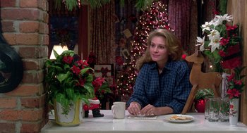 Movie still from “Steel Magnolias” (1989), directed by Herbert Ross – A woman sitting at a table with a cup of coffee; Medium shot, Over the shoulder angle