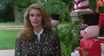 Movie still from “Steel Magnolias” (1989), directed by Herbert Ross – A woman standing in front of some bushes; Medium shot, Over the shoulder angle