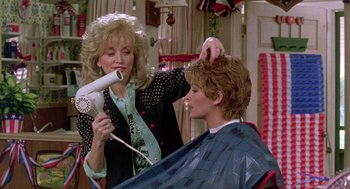 Movie still from “Steel Magnolias” (1989), directed by Herbert Ross – A woman blow drying a man's hair in a room; Medium shot, Over the shoulder angle