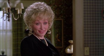 Movie still from “Steel Magnolias” (1989), directed by Herbert Ross – A woman in a black dress and a pearl necklace; Close Up shot, Over the shoulder angle