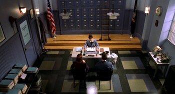 Movie still from “Stuart Little” (1999), directed by Rob Minkoff – A couple of people sitting at a table in a room; Wide shot, High angle