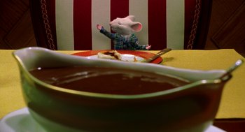 Movie still from “Stuart Little” (1999), directed by Rob Minkoff – A stuffed mouse sitting in front of a bowl of soup; Medium shot, High angle