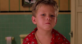 Movie still from “Stuart Little” (1999), directed by Rob Minkoff – A young boy in a red shirt is looking at the camera; Close Up shot, High angle