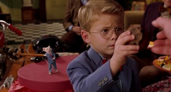Movie still from “Stuart Little” (1999), directed by Rob Minkoff – A young boy wearing glasses and a suit and tie; Medium shot, High angle