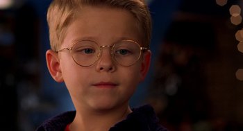 Movie still from “Stuart Little” (1999), directed by Rob Minkoff – A young boy wearing glasses looking at the camera; Close Up shot, Over the shoulder angle