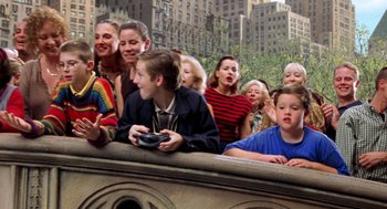 Movie still from “Stuart Little” (1999), directed by Rob Minkoff – A group of people sitting on top of a building; Medium shot, High angle