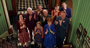 Movie still from “Stuart Little” (1999), directed by Rob Minkoff – A group of people standing next to each other clapping; Medium shot, High angle