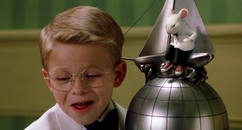 Movie still from “Stuart Little” (1999), directed by Rob Minkoff – A young boy wearing glasses and a bow tie; Medium shot, Low angle
