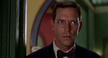 Movie still from “Stuart Little” (1999), directed by Rob Minkoff – A person wearing glasses and a bow tie; Close Up shot, Over the shoulder angle