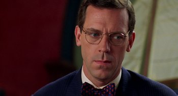 Movie still from “Stuart Little” (1999), directed by Rob Minkoff – A person wearing glasses and a bow tie; Close Up shot, Over the shoulder angle