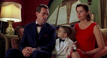 Movie still from “Stuart Little” (1999), directed by Rob Minkoff – A man and a woman sitting next to a young boy; Medium shot, Over the shoulder angle