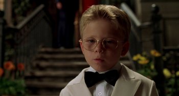 Movie still from “Stuart Little” (1999), directed by Rob Minkoff – A young boy wearing glasses and wearing a bow tie; Close Up shot, Low angle