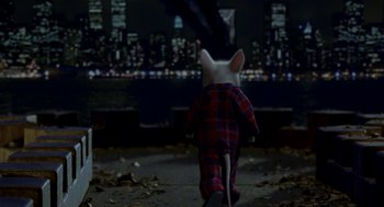 Movie still from “Stuart Little” (1999), directed by Rob Minkoff – A stuffed animal dressed in pajamas is walking on the sidewalk; Wide shot, High angle