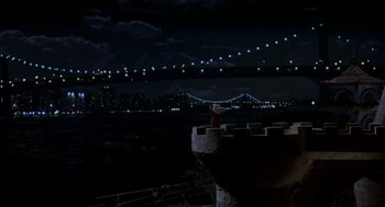 Movie still from “Stuart Little” (1999), directed by Rob Minkoff – A man standing on top of a castle at night; Extreme Wide shot, High angle