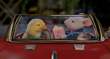 Movie still from “Stuart Little 2” (2002), directed by Rob Minkoff – A chick and a rat eating popcorn in a car mirror; Medium shot, Over the shoulder angle