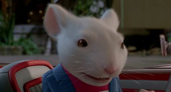 Movie still from “Stuart Little 2” (2002), directed by Rob Minkoff – A white mouse wearing a blue jacket and a pink shirt; Close Up shot, High angle