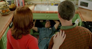 Movie still from “Stuart Little 2” (2002), directed by Rob Minkoff – A man and two women looking into a kitchen sink; Medium shot, High angle